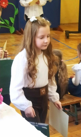 Zbliżenie na uczennicę z dyplomem – dumna chwila po podsumowaniu konkursu, zdjęcie 1 z 5 Powiatowy konkurs pt. „Bajki Adama Mickiewicza w poezji malarskiej”, fot. 1