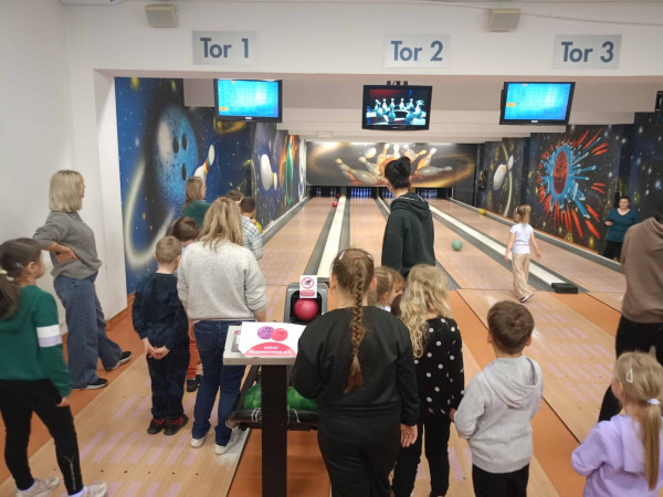 Dzieci uczestniczą w grze w kręgle, spędzając aktywnie czas wolny, zdjęcie 3 z 5