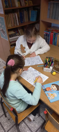 Dzieci rozwiązują zagadki obrazkowe związane z Irlandią podczas warsztatów w bibliotece, zdjęcie 1 z 3