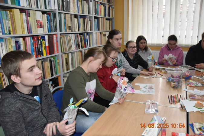 Grupa uczniów aktywnie uczestniczy w zajęciach bibliotecznych, zdjęcie 1 z 5
