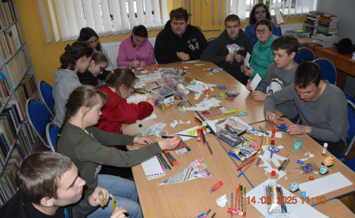Warsztaty w bibliotece – dzieci wycinają i ozdabiają elementy plastyczne przy stolikach, zdjęcie 3 z 5