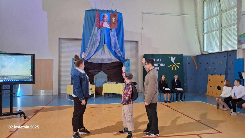 Uczniowie wskazujący na portret Jana Pawła II, zdjęcie 2 z 7