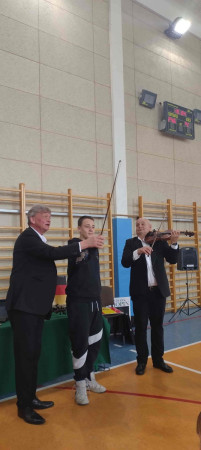 Uczeń aktywnie uczestniczy w zabawie prowadzonej przez muzyków przed publicznością szkolną, zdjęcie 3 z 3