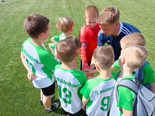 Uczniowie łączą ręce w geście drużynowej motywacji przed rozpoczęciem meczu, zdjęcie 4 z 5