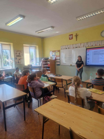 Dzieci z zainteresowaniem oglądają materiały o Gruzji na ekranie w sali lekcyjnej, zdjęcie 5 z 5