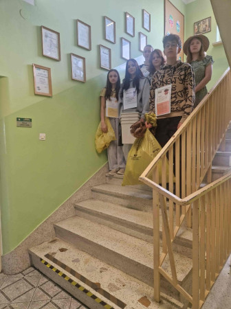 Uczniowie niosą worki ze śmieciami na szkolnych schodach podczas akcji sprzątania, zdjęcie 4 z 5