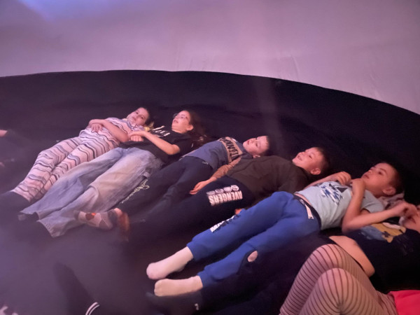 Widok wnętrza kopuły podczas seansu filmu edukacyjnego o kosmosie – dzieci patrzą ku górze, zdjęcie 4 z 5