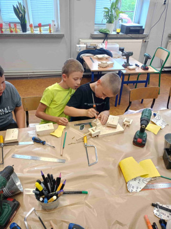 Skupieni uczniowie pracują nad projektami z drewna, zdjęcie 5 z 5