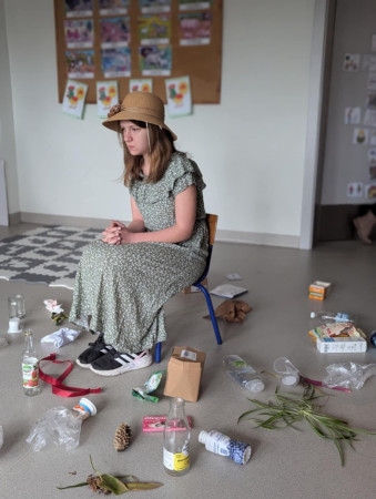 Uczennica bierze udział w scence edukacyjnej na temat segregacji odpadów, zdjęcie 1 z 5