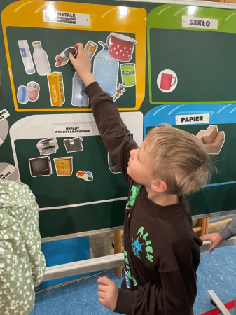 Uczeń segreguje śmieci na planszy edukacyjnej, zdjęcie 2 z 5