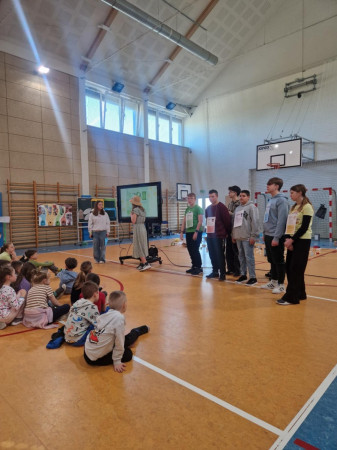 Uczniowie prowadzą prezentację na sali gimnastycznej dotyczącą gospodarki odpadami, zdjęcie 4 z 5