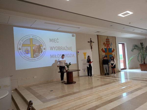 Wolontariusze Zespołu Szkół w Waganowicach prezentujący projekt 'Odnaleźć Westerplatte' podczas półfinału XVII edycji projektu 'Mieć Wyobraźnię Miłosierdzia' w auli Fides w Centrum św. Jana Pawła II w Krakowie – maj 2025, zdjęcie 1 z 3