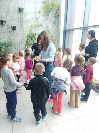 Uczniowie wchodzą do motylarni, otoczeni roślinnością i latającymi motylami, zdjęcie 1 z 5