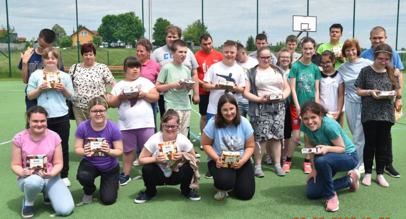 Uczniowie z radością przyjmują słodycze od seniorów podczas wizyty, zdjęcie 2 z 5