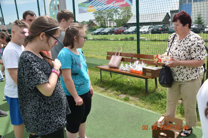 Rozmowa uczniów z seniorką podczas międzypokoleniowego spotkania w szkole, zdjęcie 3 z 5