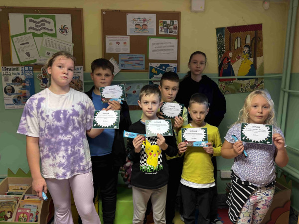 Uczniowie w bibliotece z dyplomami i słodkimi upominkami podczas Festiwalu Książki, zdjęcie 1 z 5