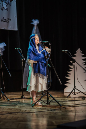 Uczennica w stroju Maryi występuje na scenie podczas Międzyszkolnego Konkursu Kolęd i Pastorałek, zdjęcie 4 z 5