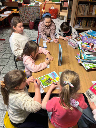 Dzieci rozwiązują zadania związane z książkami w bibliotece szkolnej, zdjęcie 3 z 5