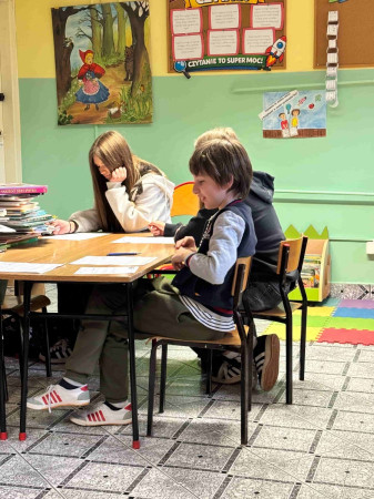 Dzieci rozwiązują zagadki związane z książkami w bibliotece szkolnej, zdjęcie 5 z 5