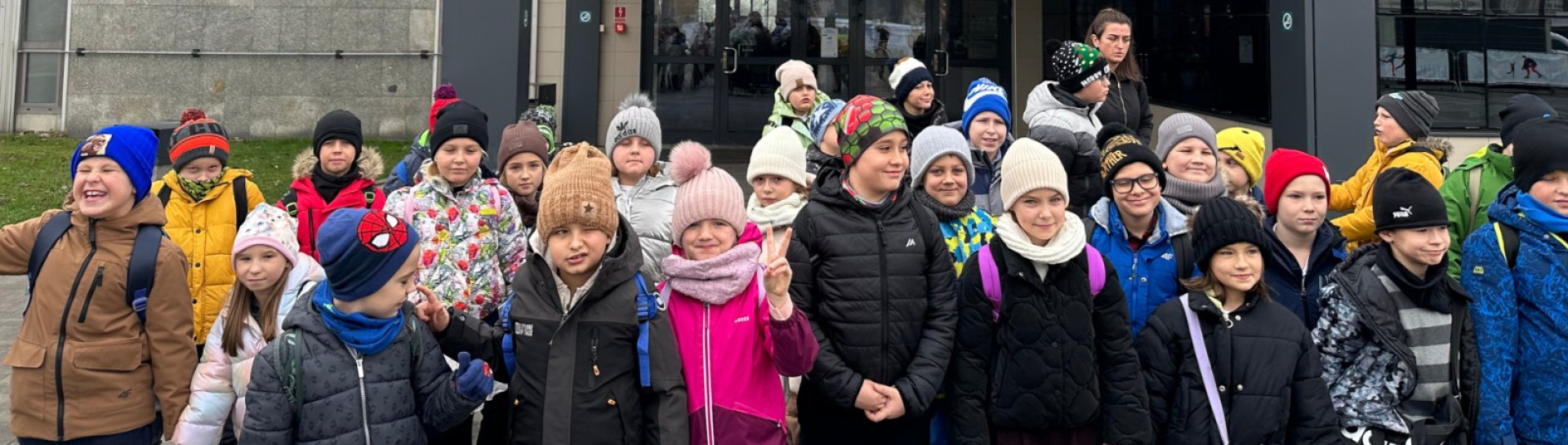 Grupa uczniów pozująca do zdjęcia przed Nowohuckim Centrum Kultury w Krakowie