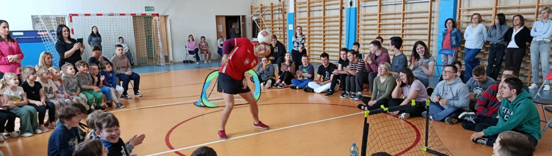 Michał Brzezicki wykonuje widowiskowe triki z piłką podczas pokazu freestyle football w szkole