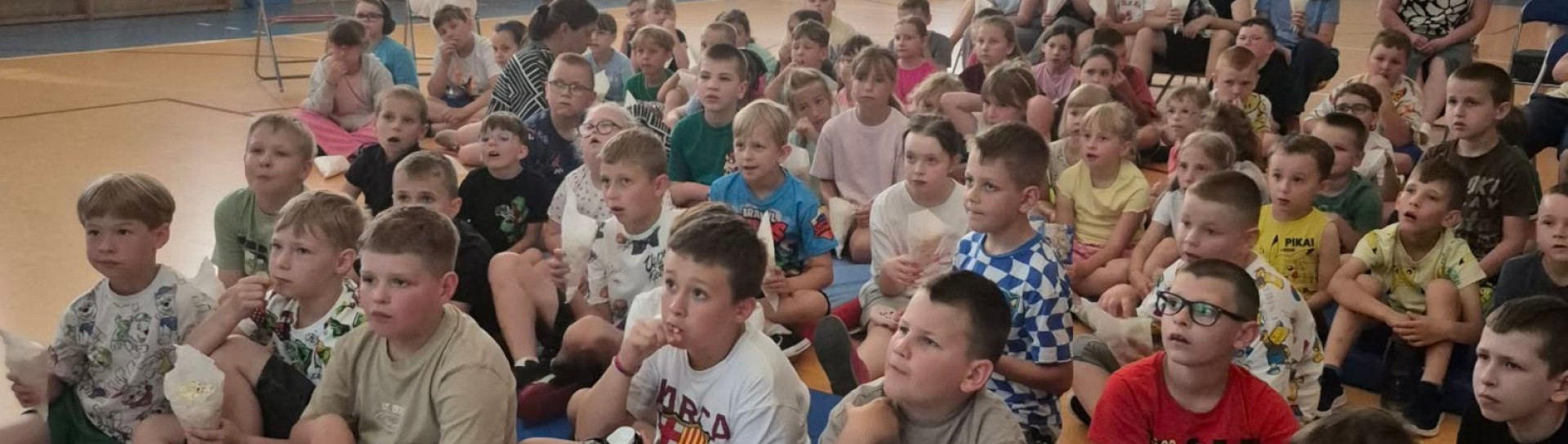 Uczniowie oglądają bajkę na sali gimnastycznej