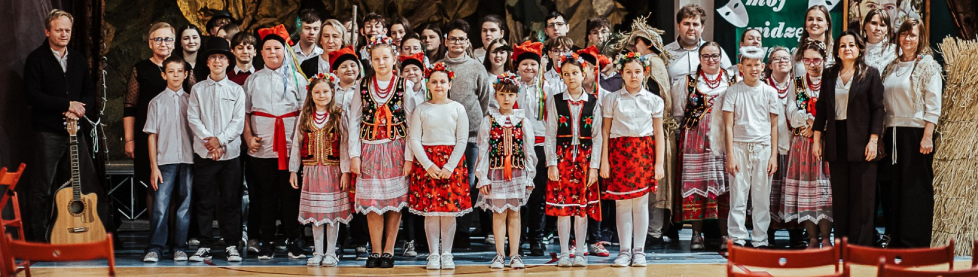 Uczniowie i nauczyciele pozują razem do wspólnego zdjęcia po akademii z okazji Święta Patrona szkoły