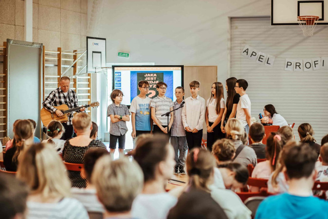 Uczniowie z nauczycielem wykonują utwór „Tolerancja” podczas zakończenia apelu profilaktycznego, zdjęcie 1 z 5